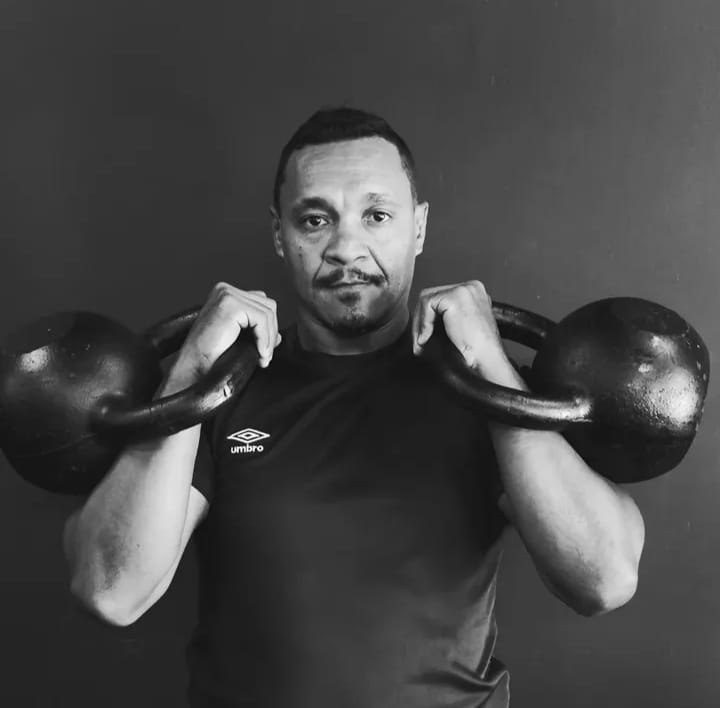 Claudinei em posição rack com dois kettlebells pesados
